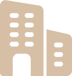 Icon of two beige buildings. The taller building on the left features ten windows and a large entrance, while the shorter building on the right has six windows. The background is transparent.
